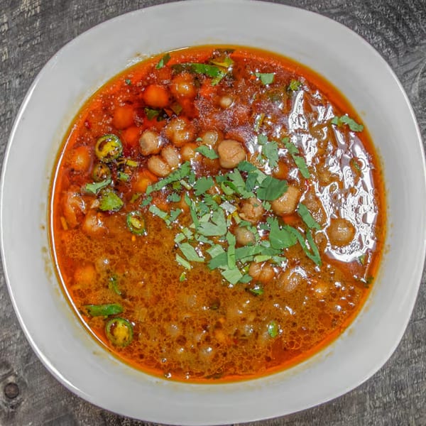 Chaat House's Chana Masala, a Pakistani chickpea curry, garnished with fresh cilantro and green chilies.