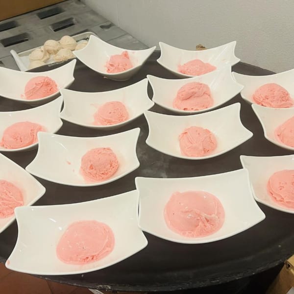 Multiple white bowls filled with scoops of pink ice cream, likely a dessert at Chaat House.