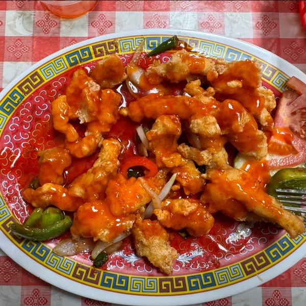 Sweet and sour chicken with peppers and onions on a decorative plate at Chaat House.