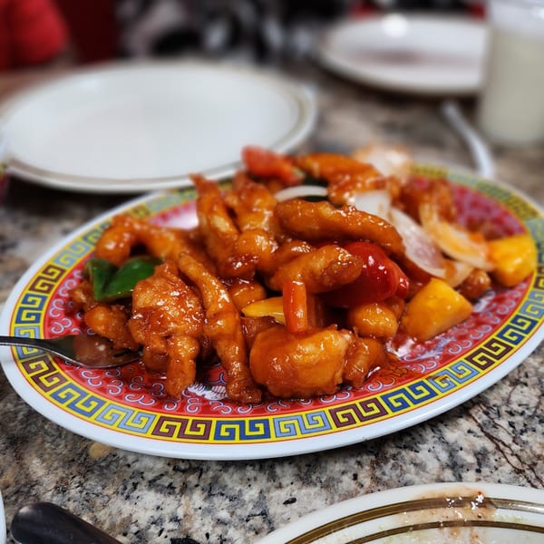 Sweet and sour chicken with peppers and onions on a decorative plate at Chaat House.